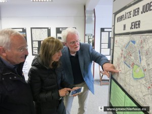 Volker Landig vom Arbeitskreis Gröschlerhaus zeigt dem Besuch eine Tafel der Ausstellung „Zur Geschichte der Juden Jevers“
